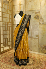 Mustard Ikat Pochampalli with black border with elephant figurines on border and black Pallu