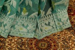 Pastel green cotton jamdani with white and gold floral design weaved all over saree