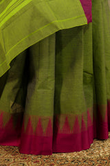 Green chettinad cotton saree with pink contrast border and traditional temple design on one side