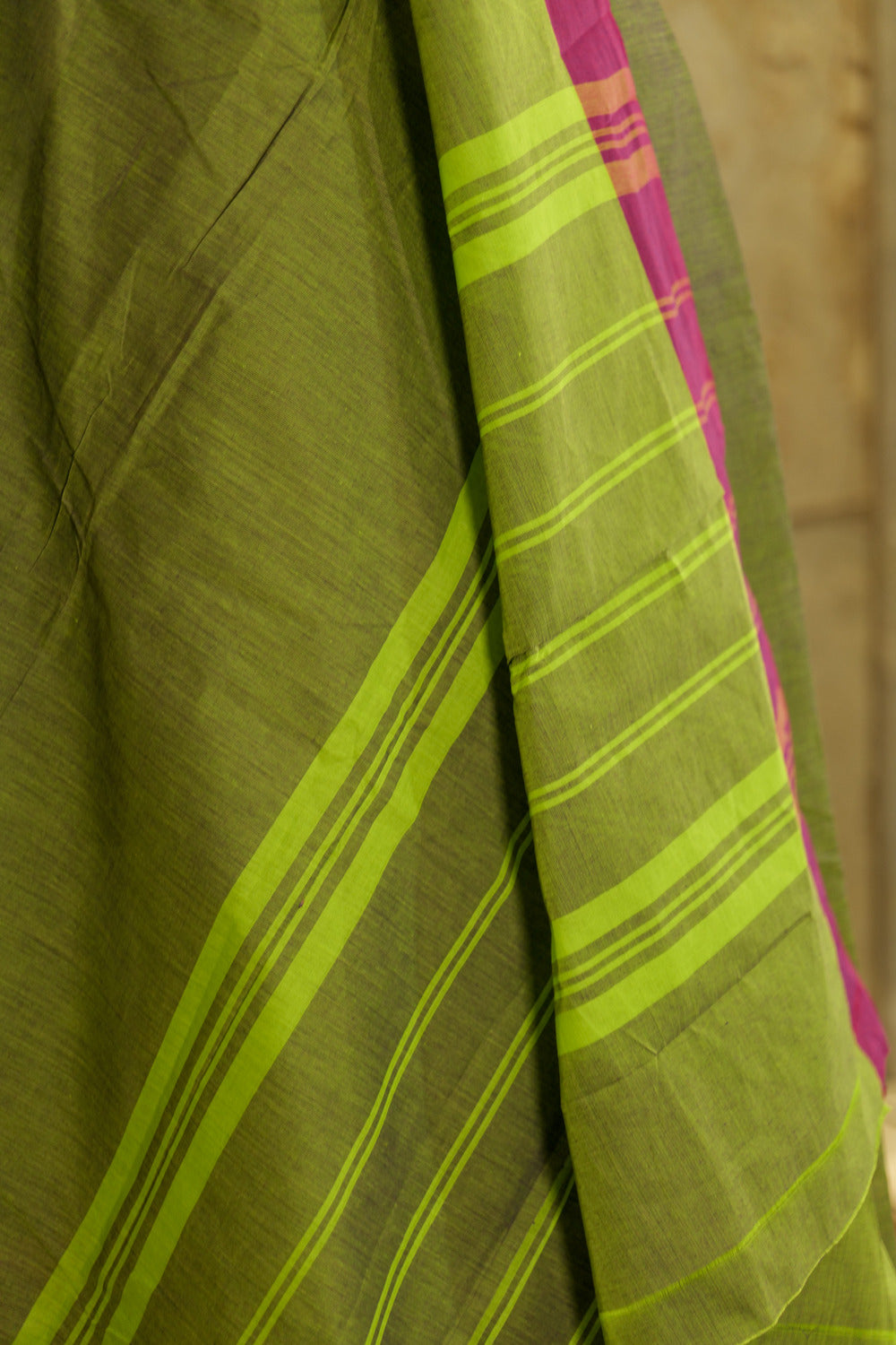 Green chettinad cotton saree with pink contrast border and traditional temple design on one side