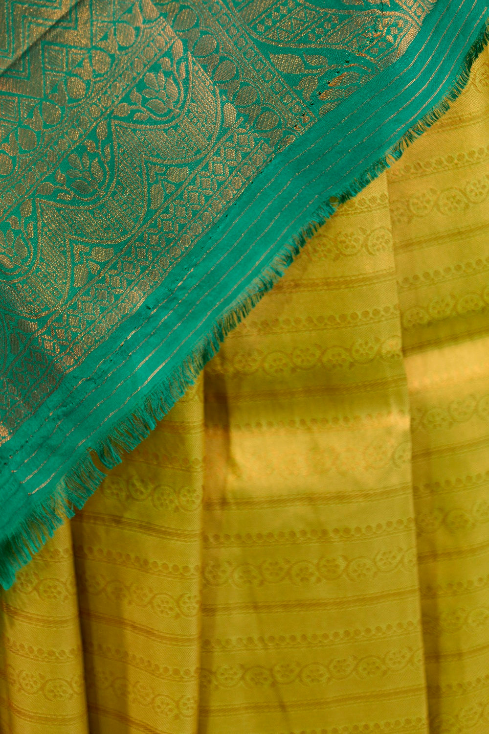 Yellow banarasi with contrast teal green rich brocade Pallu and plain teal green blouse .